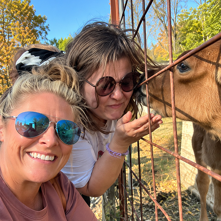 Two ladies greet a young calf in the petting zoo at Knollbrook Farm in Goshen, Indiana